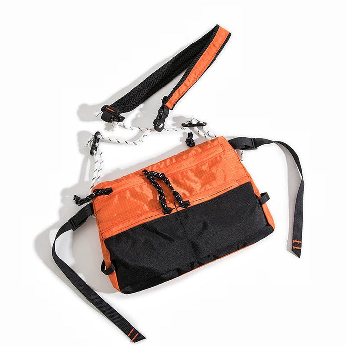 Close-up of vibrant orange outdoor sling bag, durable ripstop nylon gear for hiking.
