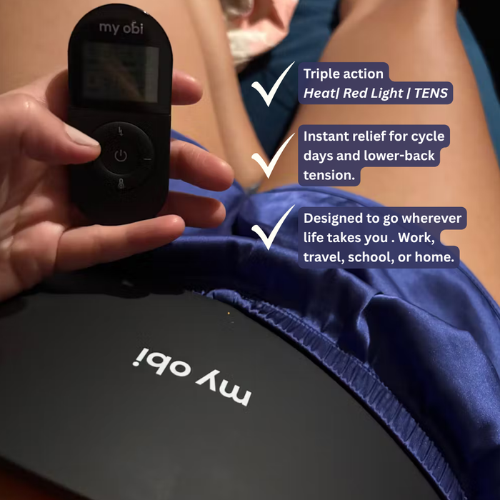 Woman using wireless heating belt for menstrual cramps at home