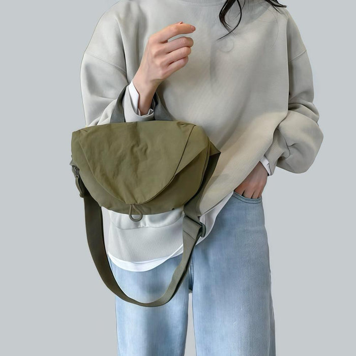 Model holding the olive green crinkle nylon bag as a casual carry.