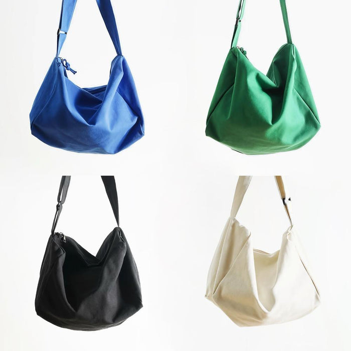Close-up of Four canvas Chic Day Hobo Bags in blue, green, black, and cream, with adjustable crossbody straps.