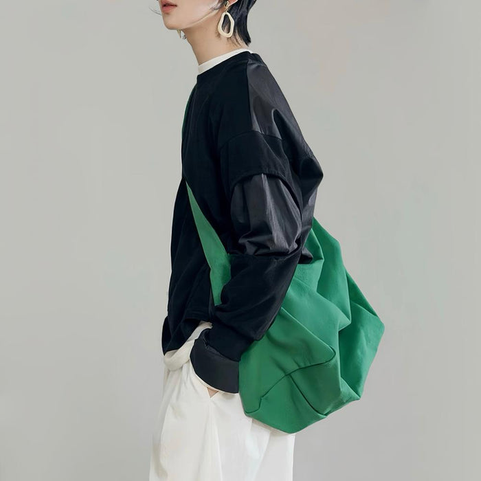 Model carrying a green bag as crossbody, great for daily carry and travel.