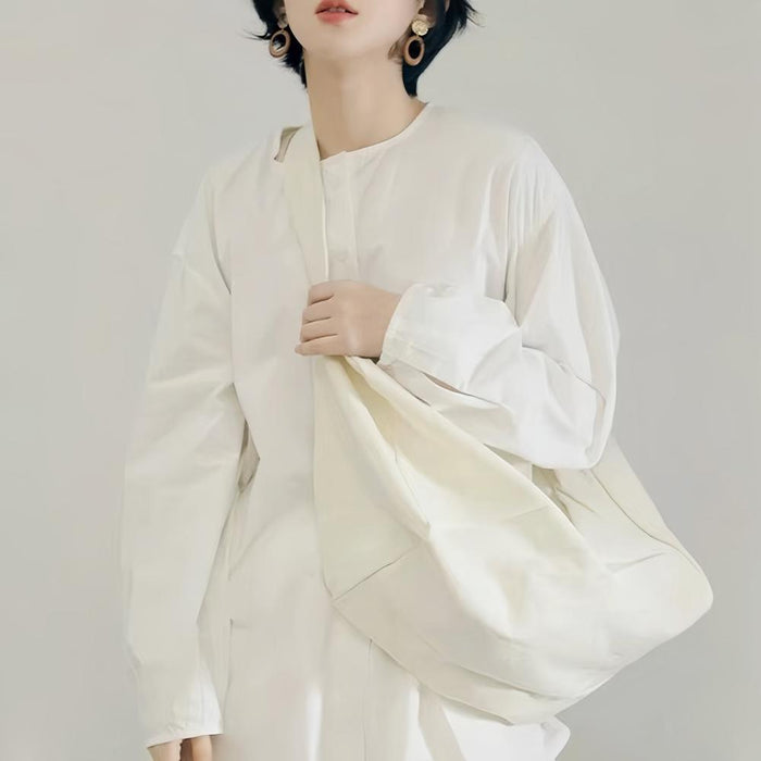 Model carrying a white bag as crossbody, great for daily carry and travel.