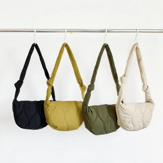 Display of the quilted crescent crossbody bags  in four colors, including black, yellow, olive green and white.