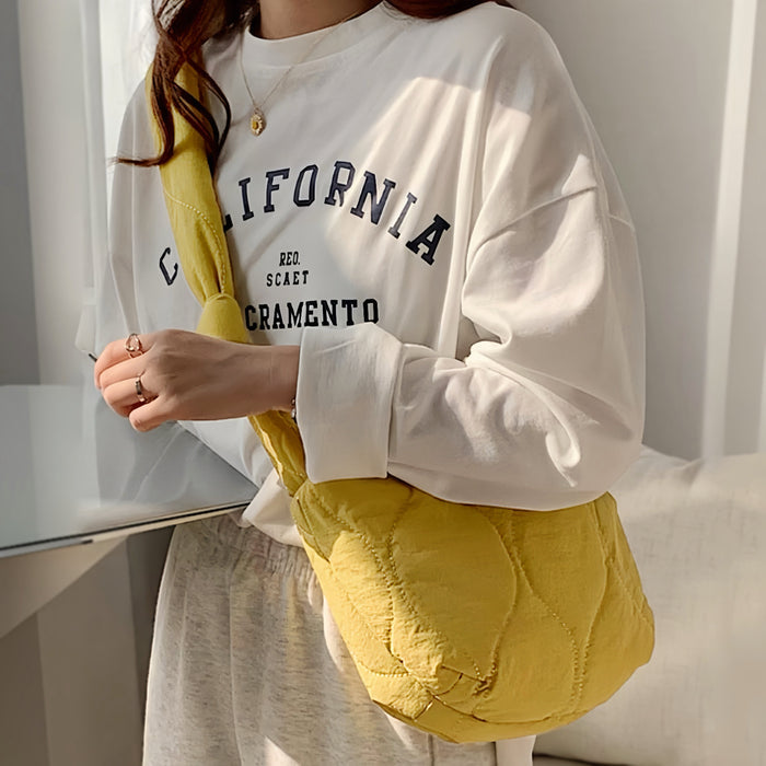 Model wearing the yellow quilted crescent bag as a front crossbody.