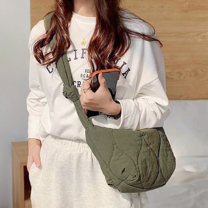 Model wearing the olive green quilted crescent crossbody bag, showing its lightweight and puffy design.