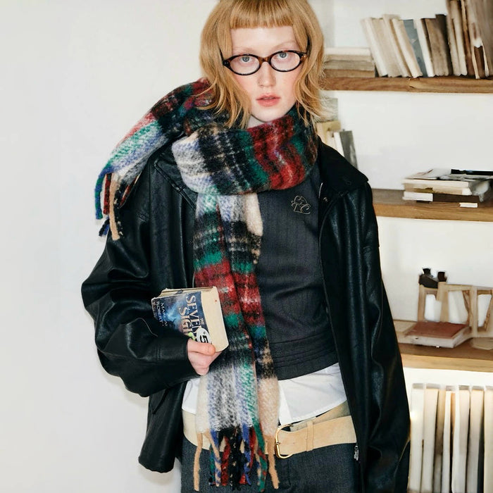 Model wearing a plaid wool scarf in green and red, easy for weekend styling and gifting.