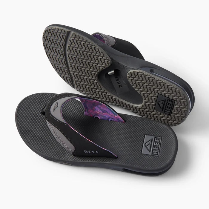 Fanning REEF black flip flops, one facing left with outsole visible and one facing right with footbed visible