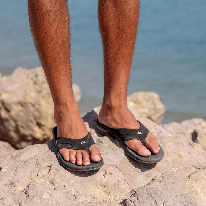 Fanning sandals on a man’s feet facing forward, showing soft-rebound cushioning and anatomical arch support.