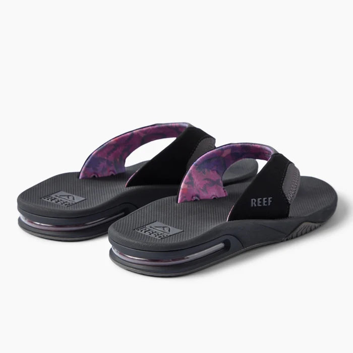 REEF Fanning black flip flops facing left with patterned straps and cushioned footbeds