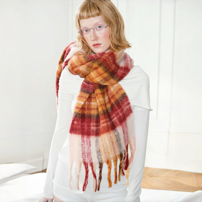 Model wearing Fiery Sunrise Plaid Scarf: Wool blend with red, orange, and yellow plaid pattern.