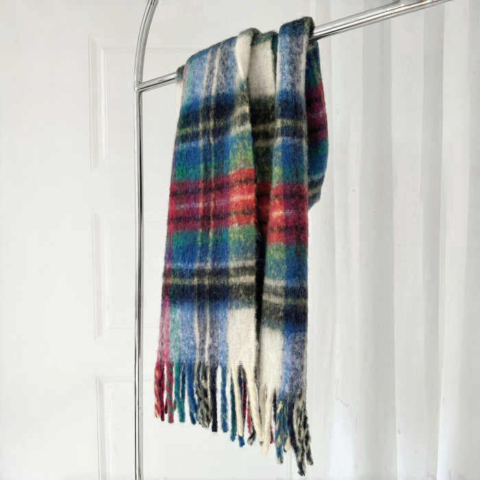 Flat lay of Crimson Meadow Plaid Scarf in green and red, great for office layering and commuting.