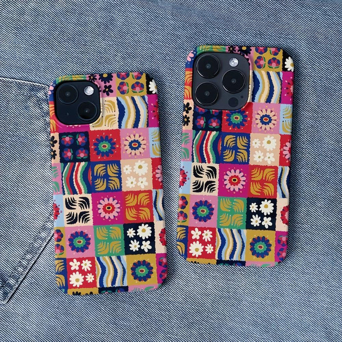 Floral patchwork silicone case shown on a denim background. Vintage-inspired aesthetic lifestyle shot.