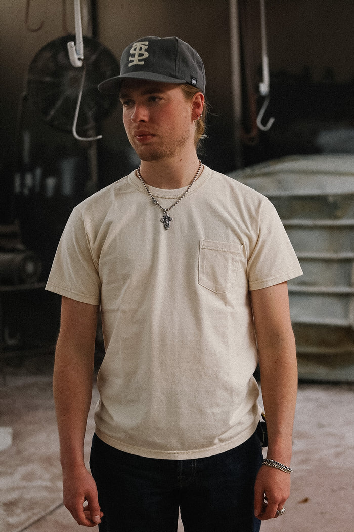 man wearing cream t-shirt on blurred background