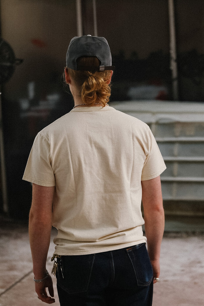 man wearing cream t-shirt on blurred background