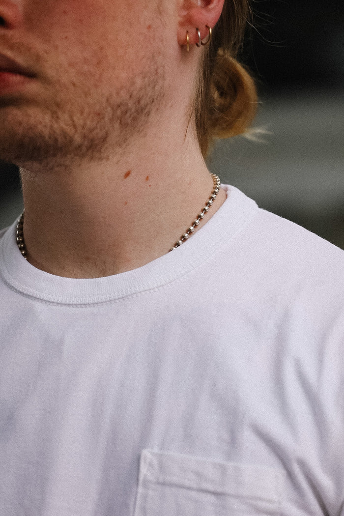 Close-up of a light gray t-shirt with a pocket
