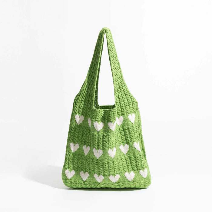 Green blended knitting yarn crochet bag with white heart pattern.