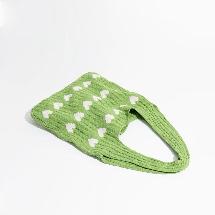 Green blended knitting yarn crochet bag with white heart pattern and short straps.