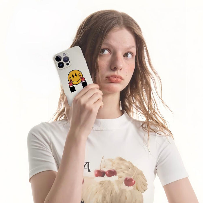 Held by a woman, white silicone case with a yellow smiley face and red hands. Playful Gen-Z fashion.
