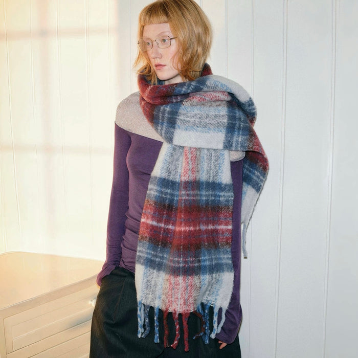 Model wearing Midnight Blaze Plaid Scarf, a long wool blend scarf with red, blue, and white plaid, ideal for daily.