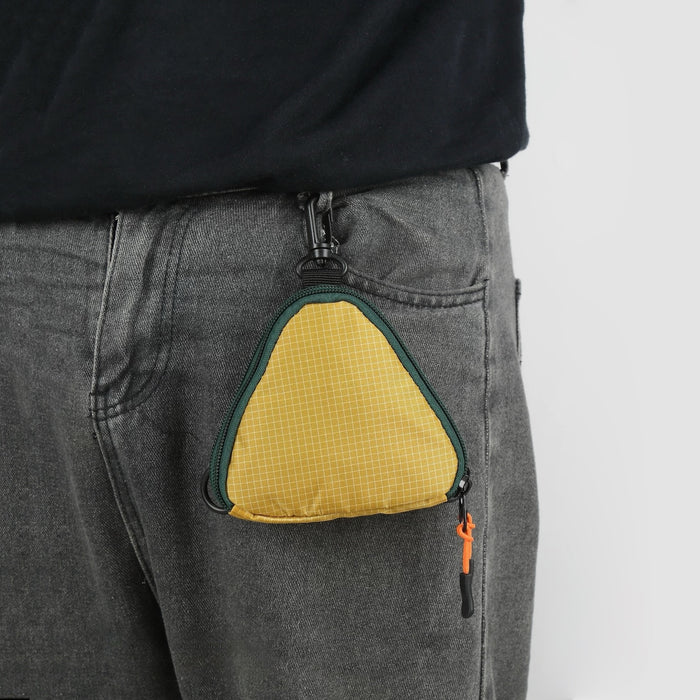 Close-up of a triangle multi-use bag clipped to a belt loop, showing hands-free storage for keys and cards.