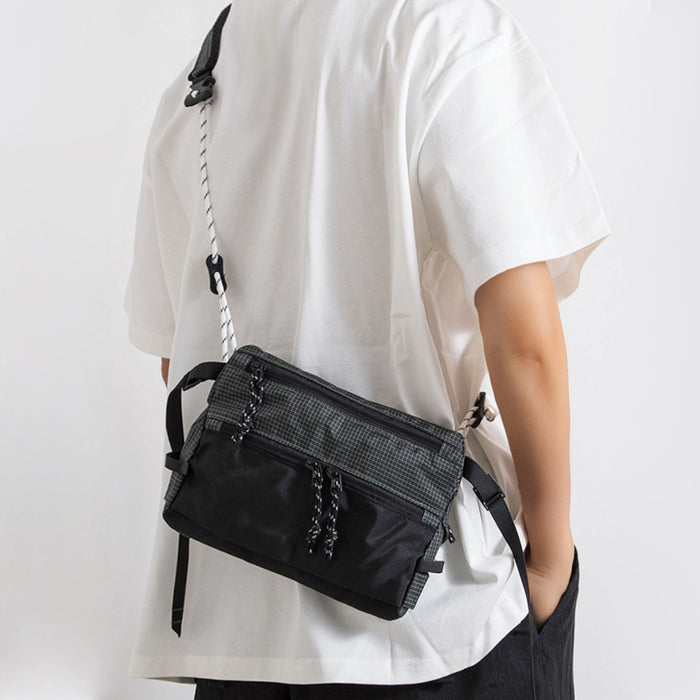Back view of model with black outdoor leisure sling bag, ergonomic techwear styling.