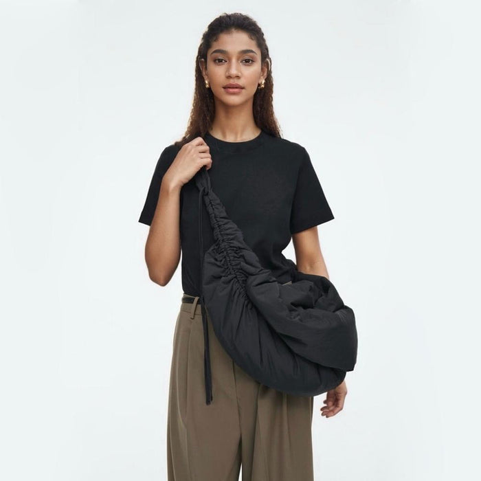 Model wearing the oversized black duvet crescent bag, showcasing its large, slouchy fit.