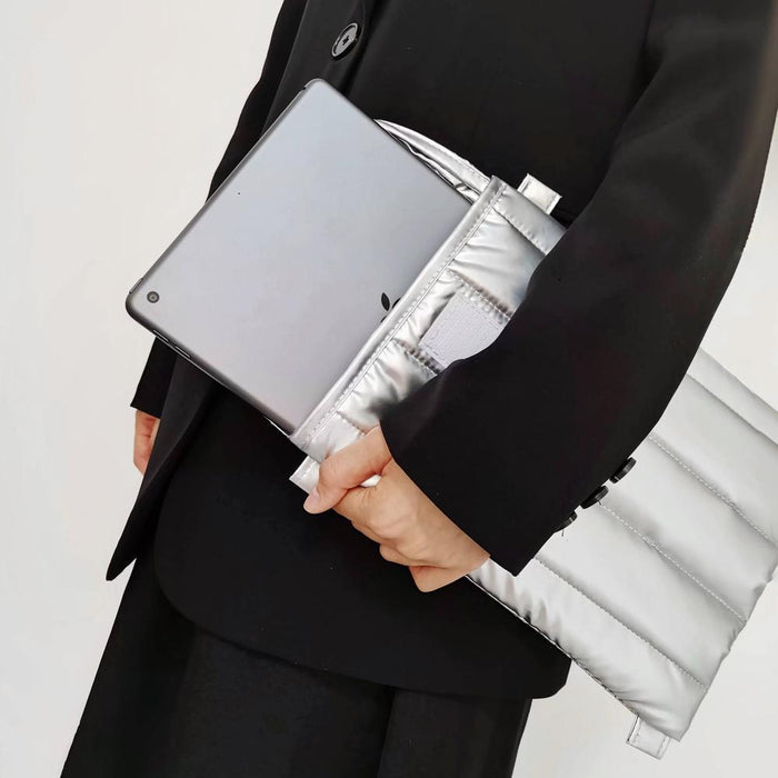Model carrying  a Silver padded polyester laptop sleeve handheld, easy for commuting.
