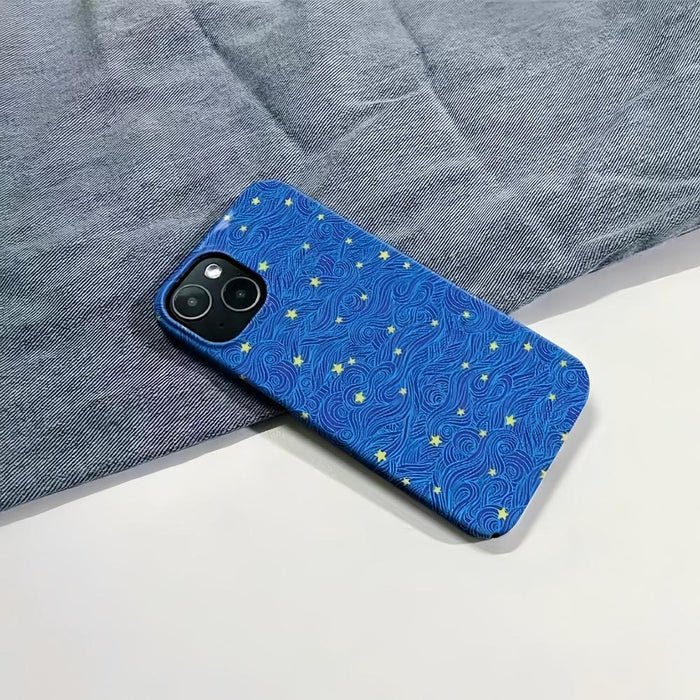 Blue Starry Night case with yellow stars and swirling lines, resting on a denim background.