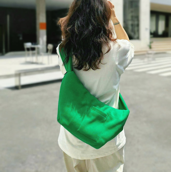 Model carrying a green Twist & Tie Sleeve Bag as crossbody, easy for commuting and weekends.