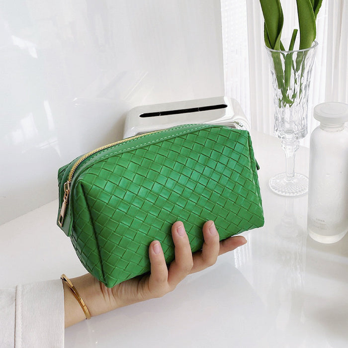Model holding a green woven makeup bag in hand, easy to carry for travel and errands.
