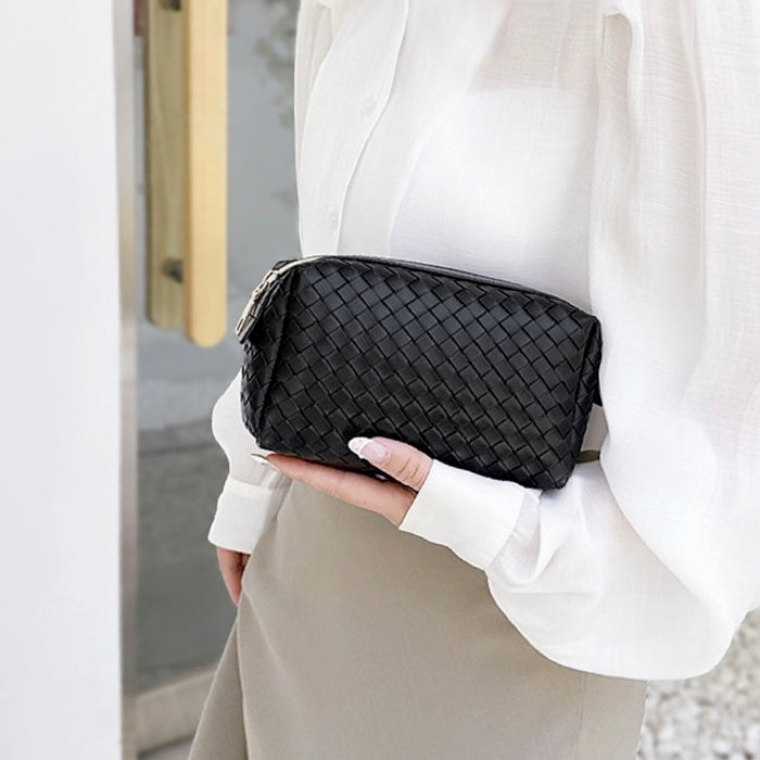 Model holding a black makeup bag in hand, easy to carry for travel and errands.
