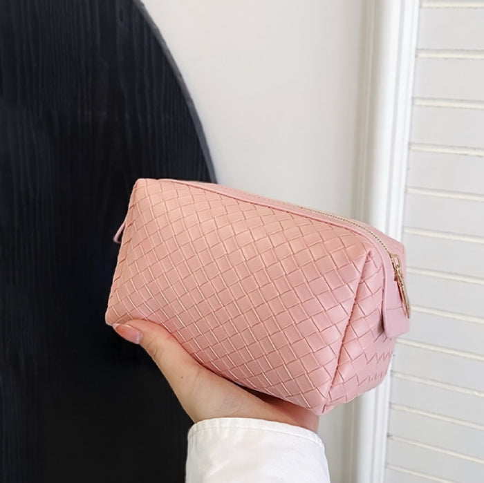 Model holding a pink makeup bag in hand, great for on-the-go touch-ups.
